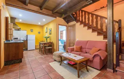 a living room with a pink couch and a kitchen at apartamentos castrovaselle nº2 in Castrovaselle