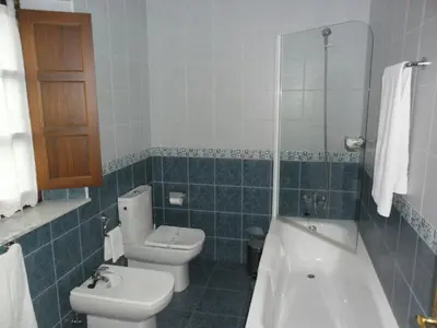 a bathroom with a toilet and a tub and a sink at apartamentos castrovaselle nº2 in Castrovaselle