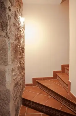 a set of stairs in a room with a stone wall at A Quinta Das Maceiras in San Miguel de Castro