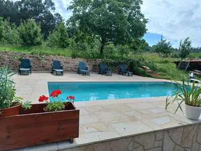 a patio with chairs and a swimming pool at A Quinta Das Maceiras in San Miguel de Castro
