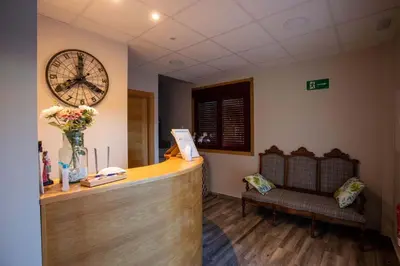 a reception desk with a large clock on the wall at PENSIÓN CASA ANTONIO in Pantón