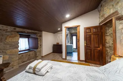 a bedroom with a large bed and a wooden ceiling at Casa Pion in Sober