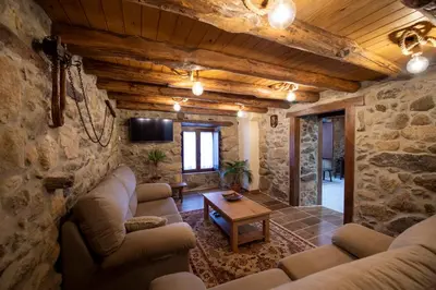 a living room with couches and a tv in a stone wall at Casa Pion in Sober