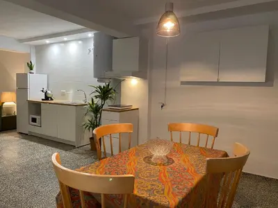 a dining room table with chairs and a kitchen at Apartamento Padrón Centro P2 by URent in Padrón