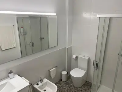 a bathroom with a toilet and a sink and a mirror at Apartamento Padrón Centro P2 by URent in Padrón