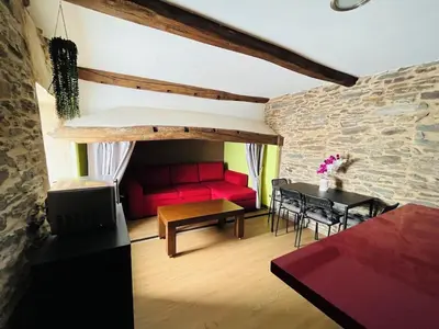 a living room with a red couch and a table at Casa rural entre Santiago Compostela y La Coruña in Ordes