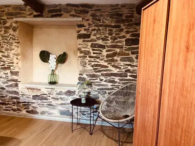 a room with a stone wall and two chairs and a table at Casa rural entre Santiago Compostela y La Coruña in Ordes