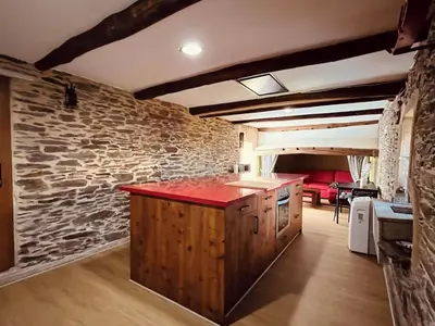 a kitchen with a red counter and a stone wall at Casa rural entre Santiago Compostela y La Coruña in Ordes