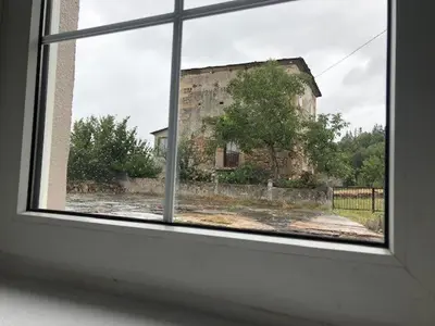 a window view of an old stone building from a house at casa ferreirua in Ferreirúa