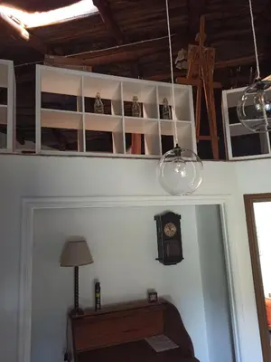 a room with a table and a clock and lights at casa ferreirua in Ferreirúa