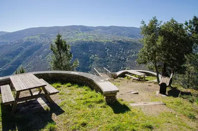 a picnic table and bench on a hill with a view at casa ferreirua in Ferreirúa