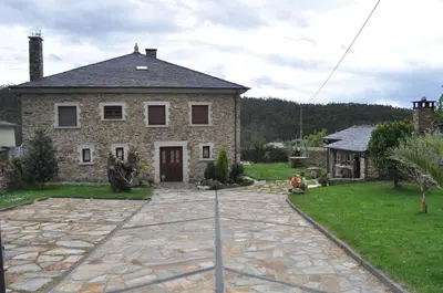 a large brick house with a stone driveway at APARTAMENTOS RURALES CASTRO DE VILAOSENDE in Ribadeo