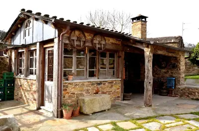 a bedroom with a bed and a stone wall at APARTAMENTOS RURALES CASTRO DE VILAOSENDE in Ribadeo