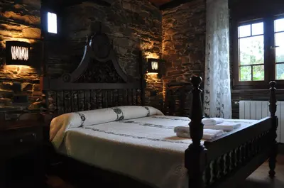 a bedroom with a bed with two towels on it at APARTAMENTOS RURALES CASTRO DE VILAOSENDE in Ribadeo
