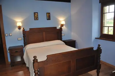 a bedroom with a bed with red walls and a window at APARTAMENTOS RURALES CASTRO DE VILAOSENDE in Ribadeo
