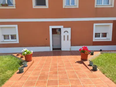 a house with a brick patio with potted plants at Apartamentos turísticos Lemos in Pedrouzo