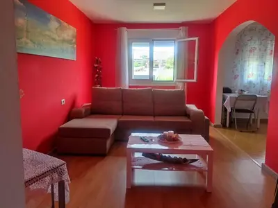 a living room with red walls and a couch and a table at Apartamentos turísticos Lemos in Pedrouzo