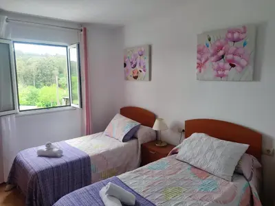a bedroom with two beds and a window at Apartamentos turísticos Lemos in Pedrouzo