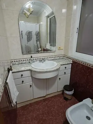 a bathroom with a sink and a mirror at Apartamentos Shalom Ribadeo in Ribadeo