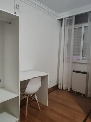 a white desk and a chair in a room at Apartamentos Shalom Ribadeo in Ribadeo