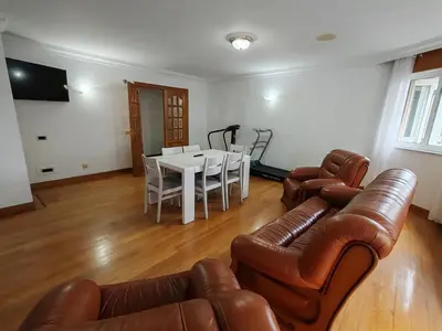 a living room with a couch and a table and chairs at Apartamentos Shalom Ribadeo in Ribadeo