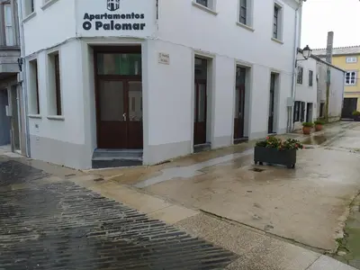 a white building with a door on a street at Apartamentos turísticos o palomar in Villalba
