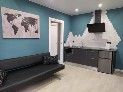 a living room with a couch and a sink and a kitchen at Apartamentos turísticos o palomar in Villalba