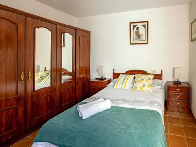a bedroom with a bed and wooden cabinets at QUINTA do SOUTO BARCIADEMERA in Barciademera