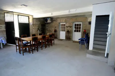 a dining room with a wooden table and chairs at QUINTA do SOUTO BARCIADEMERA in Barciademera