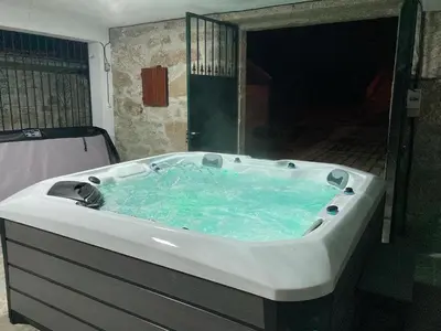 a large bath tub with blue water in a bathroom at QUINTA do SOUTO BARCIADEMERA in Barciademera
