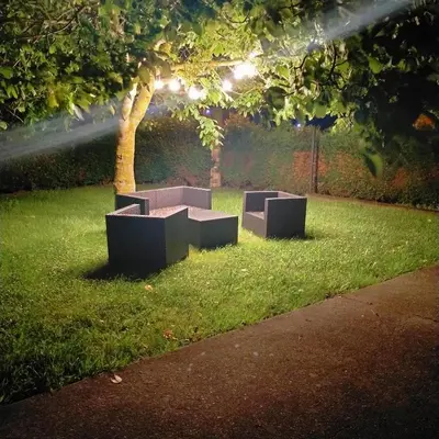 two benches sitting in the grass under a tree at Vivienda uso turistico Los Nogales in Foz