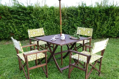 a wooden table with four chairs and an umbrella at Vivienda uso turistico Los Nogales in Foz