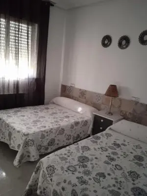 a bedroom with two beds and a window at Vivienda uso turistico Los Nogales in Foz