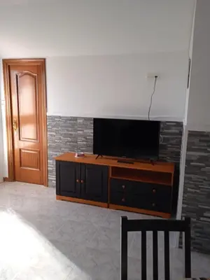 a living room with a flat screen tv on a dresser at Vivienda uso turistico Los Nogales in Foz