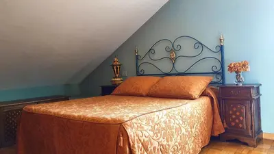 a bedroom with a bed and a blue wall at Casa de Pepa en Ribadeo in Ribadeo