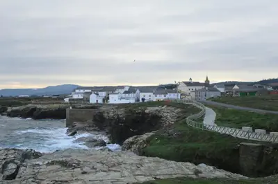 a group of white houses on a hill next to a river at Casa de Pepa en Ribadeo in Ribadeo