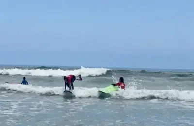 a group of people on surfboards in the ocean at Casa de Pepa en Ribadeo in Ribadeo