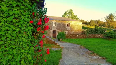 a hedge of red flowers on a house at Casa Berdeal in Santa María