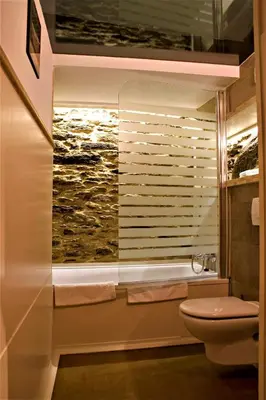 a bathroom with a toilet and a window with a painting at Casa Berdeal in Santa María