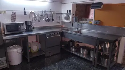 a kitchen with a sink and a stove and a microwave at Casa Berdeal in Santa María