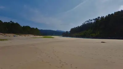 a beach with footprints in the sand next to a river at Casa Berdeal in Santa María