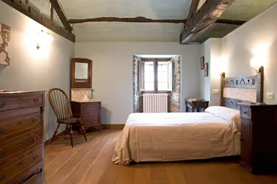 a bedroom with a bed and a dresser and a window at Casa Berdeal in Santa María