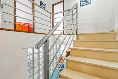a metal staircase in a home with white walls at Apartamentos Turisticos As Cetareas in Rinlo