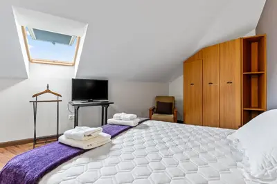 a bedroom with a large bed with towels on it at Apartamentos Turisticos As Cetareas in Rinlo