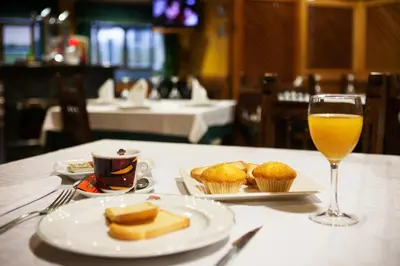 a table with a plate of food and a glass of orange juice at Hotel San Briz in A Pontenova