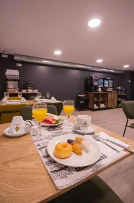 a table with plates of food and glasses of orange juice at U-Hotel Darío Lugo in Lugo