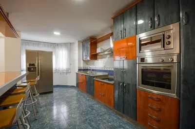 a kitchen with wooden cabinets and stainless steel appliances at U-Hotel Darío Lugo in Lugo
