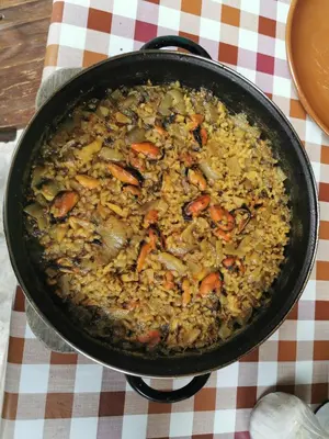 a pan filled with food on a table at Habitación Cuadruple con derecho a Barbacoa y patio in Navia de Suarna