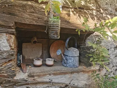 a small house with pots and a watering can at Habitación Cuadruple con derecho a Barbacoa y patio in Navia de Suarna