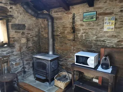 a kitchen with a microwave and a stove at Habitación Cuadruple con derecho a Barbacoa y patio in Navia de Suarna